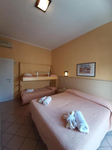 a bedroom with two beds with towels on them at Hotel Originale by ALEhotels in Rimini