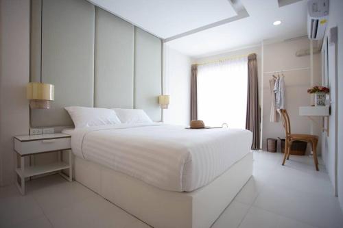 una camera da letto bianca con un letto grande e una finestra di Sclass HOME Private, Central old city (Wholehouse) a Chiang Mai