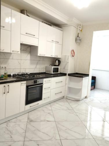 a white kitchen with white cabinets and appliances at НОВОБУДОВА,СТРИЙСЬКА,Автовокзал ,СИХІВ ARENA Карла Мікльоша in Lviv