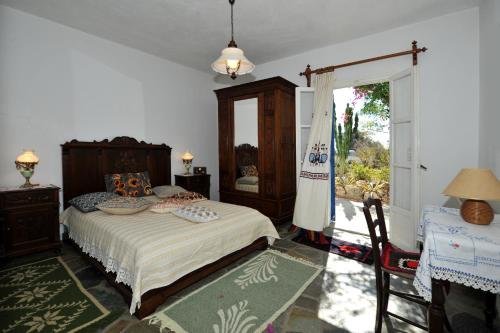 1 dormitorio con cama y ventana grande en Paros traditional house en Episkopianá