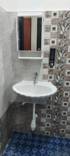 a white sink in a bathroom with a mirror at Marias house in Siroda