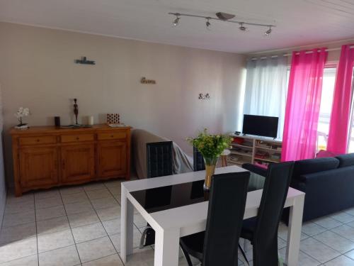 a living room with a table and a couch at Appartement spacieux et lumineux Secteur Petit Marché à 5 min a pied de la plage in Saint-Jean-de-Monts