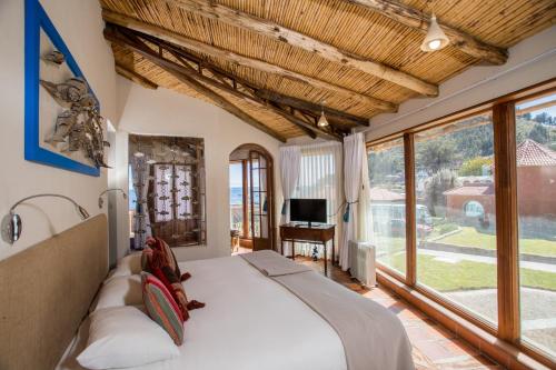 ein Schlafzimmer mit einem Bett und einem großen Fenster in der Unterkunft Hotel Rosario Lago Titicaca in Copacabana