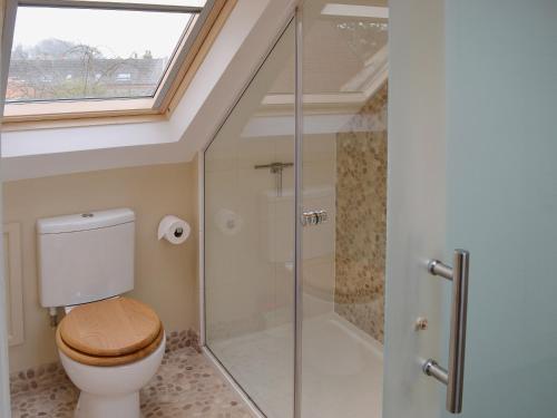 a bathroom with a toilet and a glass shower at Maison De Quai in Cley next the Sea