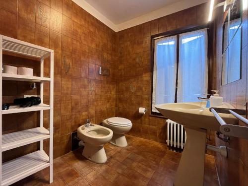 bagno con lavandino, servizi igienici e finestra di Anfite Apartments Aleardi a Peschiera del Garda