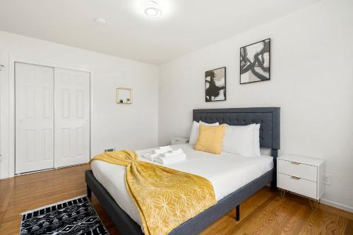 a bedroom with a bed with a yellow blanket on it at Cozy 2 Bedroom Home Near SFO with Private Parking in San Bruno