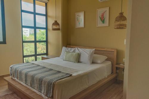 een slaapkamer met een bed en een raam bij Mythical Hotel - Boutique in Medellín
