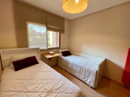 - une chambre avec 2 lits et une fenêtre dans l'établissement Sofia’s placeCosy ground floor Appartement RDJ, à Marrakech