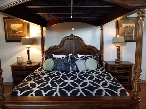 a bedroom with a canopy bed with blue and white pillows at Tuscan Manor in Eureka Springs