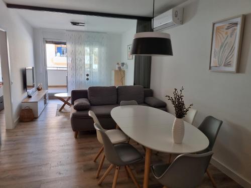 un soggiorno con tavolo, sedie e divano di Alena Home - Prestige and new apartment a Premantura