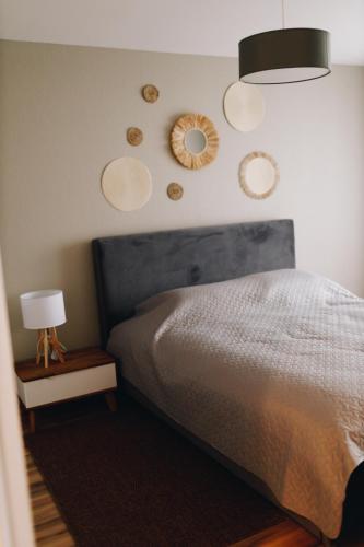 a bedroom with a bed and two mirrors on the wall at LK Apartment in Rēzekne