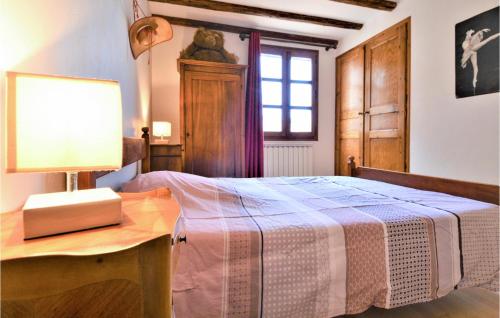 um quarto com uma cama e uma mesa com um candeeiro em 4 Bedroom Lovely Home In Marguerittes em Marguerittes