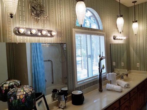 a bathroom with a sink and a window and a mirror at Tuscan Manor in Eureka Springs