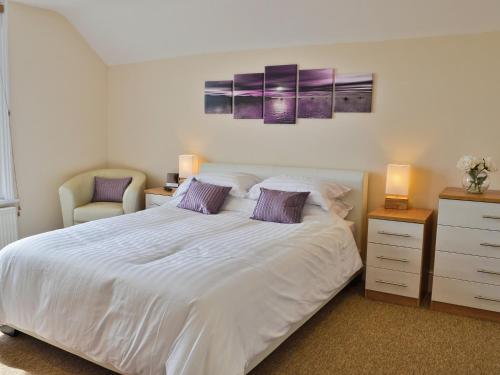 a bedroom with a large white bed and a chair at Nemo in Sandown
