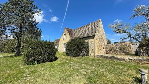 une ancienne église en pierre sur un champ herbeux dans l'établissement La Combe d’Estève, à Carsac-Aillac