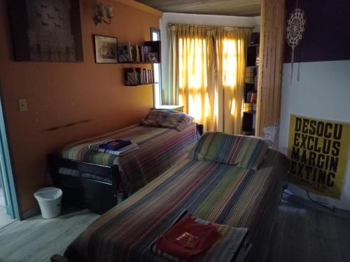 a bedroom with two beds and a window at Cuartos en el segundo piso de casa de artista en Flores in Buenos Aires