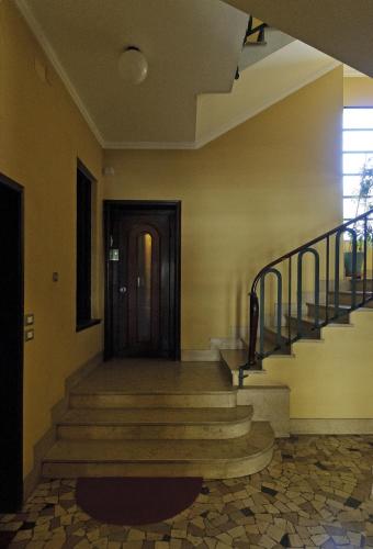 a hallway with stairs and a wooden door at Casatitta Bed & Breakfast in Milan