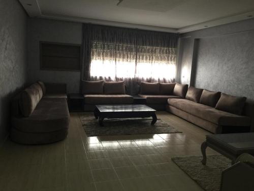 uma sala de estar com um sofá e uma mesa de centro em Appartement à casablanca em Tafza