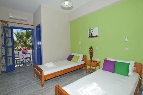 sala de estar con 2 camas y balcón en Nikolas Villas, en Perivolos