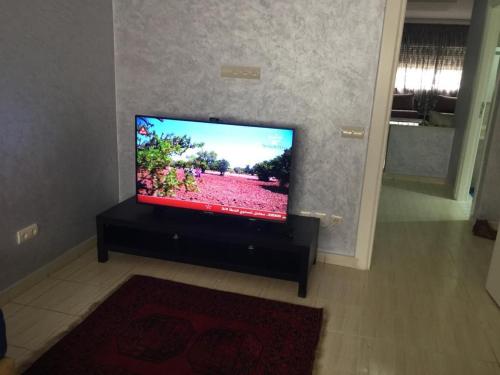 uma televisão de ecrã plano numa bancada numa sala de estar em Appartement à casablanca em Tafza