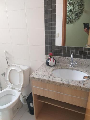 a bathroom with a toilet and a sink at Apartamento no Condomínio Casa da Madeira em Caldas Novas-GO in Caldas Novas