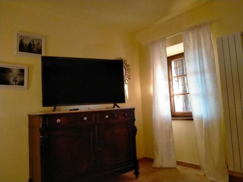 a flat screen tv on top of a dresser with a window at Ca'di Picarasco in Bagnone