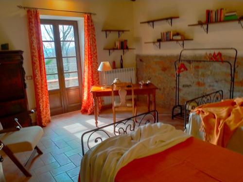 a bedroom with a bed and a table and a desk at Ca'di Picarasco in Bagnone