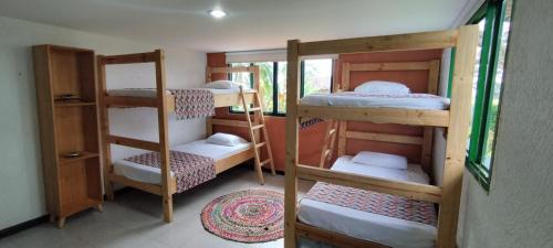 a room with three bunk beds in a room at Finca la castellana in Quimbaya