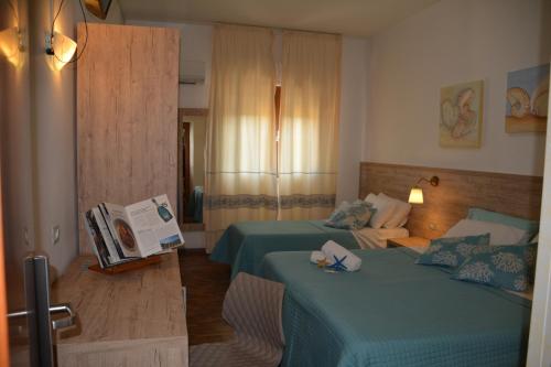 Habitación de hotel con 2 camas y sofá en Hotel Citti, en Arzachena