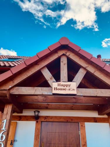 un cartello sul tetto di una casa di legno di Happy House - Kaszubska Ostoja a Barkocin