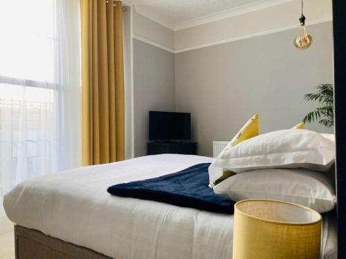 a bedroom with a bed with pillows and a television at The Morley in Torquay