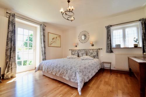 a bedroom with a bed and two windows at la suite Au bon Marechal in Giverny