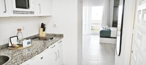 a white kitchen with white cabinets and a sink at ESTRENO Benalbeach vistas al mar Estudio DELUXE in Benalmádena