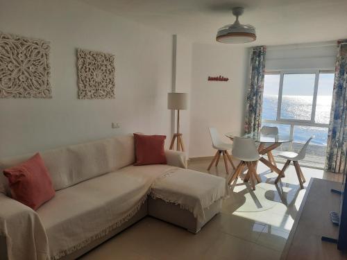 een woonkamer met een bank en een tafel bij Primera linea de Playa a 10 min Estepona in San Luis de Sabinillas