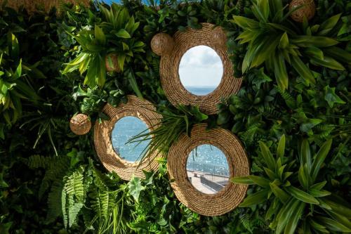 una corona de plantas y espejos en una pared en 1ªLinea Mar-Piscina-Wifi-PortAventura-Luxury-Chill5, en Salou