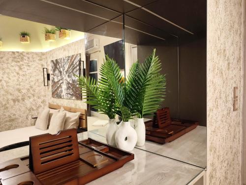 a bedroom with a mirror and vases with plants in it at Elia Studio in Athens