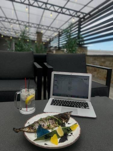 a plate of food and a laptop computer on a table at Козацькі Забави in Rivne