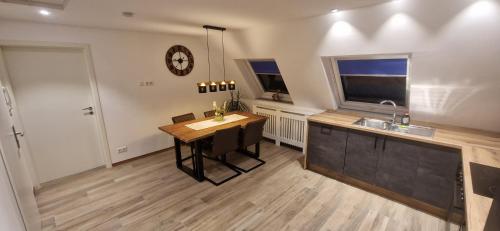 a kitchen with a table and a clock on the wall at Renatas Ferienwohnung Sasbachwalden in Sasbachwalden