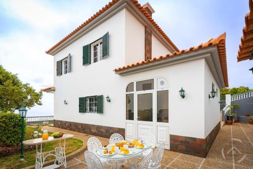 a white house with a table and chairs at Garden House in Funchal