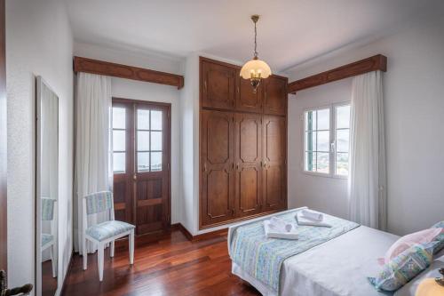a bedroom with a bed and a chair in it at Garden House in Funchal