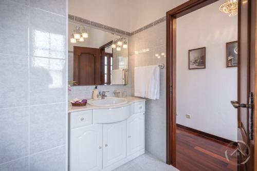 a white bathroom with a sink and a mirror at Garden House in Funchal