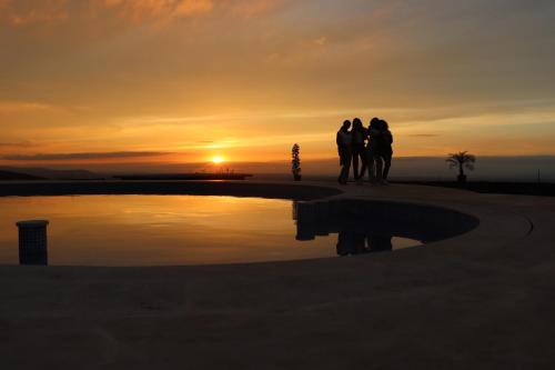 a group of people standing by a pool at sunset at Bhalil Farm House in Sefrou