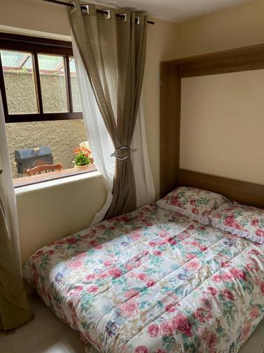 a bedroom with a bed and a window with a curtain at Recanto de Itaipava - casa com forno de pizza a lenha, churrasqueira, pet friendly, equipada para até 6 pessoas, em meio à Natureza e próxima ao centro do bairro in Araras Petropolis