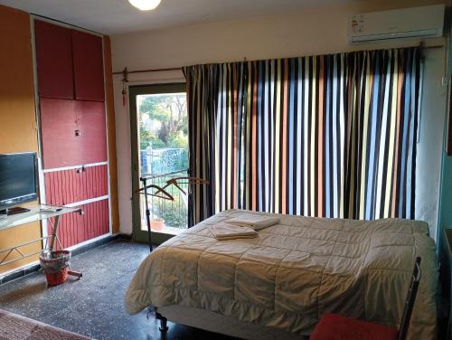 1 dormitorio con cama y ventana grande en "El Pelícano" Hostal en Maldonado