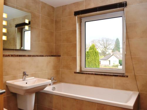 a bathroom with a sink and a tub and a window at Gatesgarth in Keswick