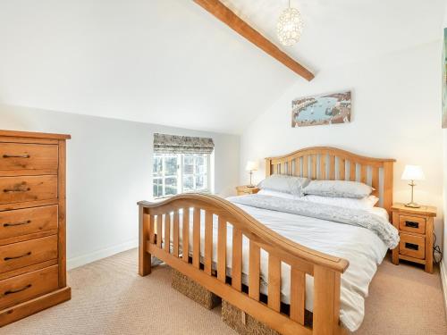 a bedroom with a wooden bed and a wooden dresser at Beverley House - Uk43519 in Thornton Dale