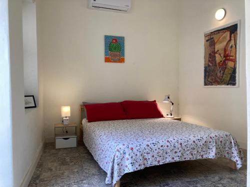 ein Schlafzimmer mit einem Bett mit roten Kissen darauf in der Unterkunft B&B Belvédère - unique monument in the old city in Willemstad