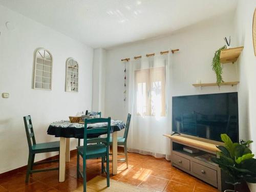 ein Esszimmer mit einem Tisch und einem TV in der Unterkunft Casa Lucia Albaicin con terraza in Granada