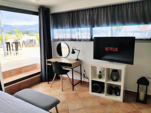 a bedroom with a television and a desk and a table at #Roof(pool)garden Private in Pikérmion