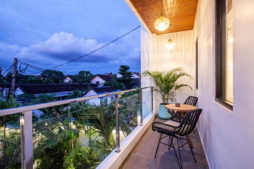 a balcony with a table and chairs and a view at Zayana Villas Resort Seminyak in Seminyak